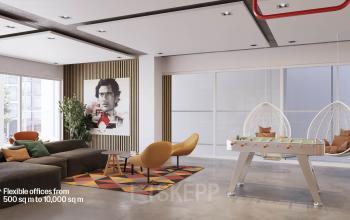 Modern lounge area in an office building at Jacob Bontiusplaats 9, Amsterdam East, featuring comfortable seating, a foosball table, and bright decor.