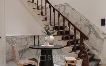 Elegant entryway at Jacob Obrechtstraat 56, Amsterdam Old South, ideal for office space rental, featuring a stylish staircase and modern furniture.