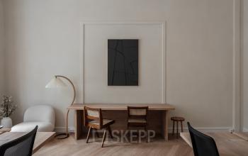 Contemporary office space rental at Jacob Obrechtstraat 56, Amsterdam Old South, featuring a stylish wooden desk with chairs and tasteful decor.