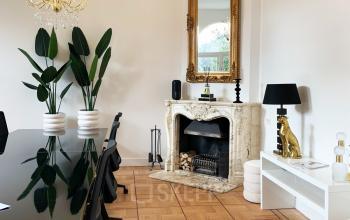 Elegant office space available for rent in Amsterdam Old South, featuring a stylish conference table, decorative fireplace, and chic furnishings at Emmalaan 7-9.