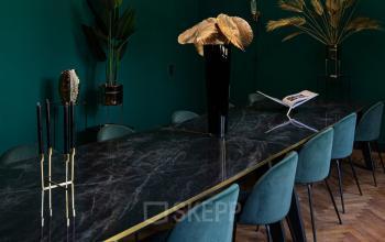Furnished office space with a long marble table and teal chairs, located at Emmalaan 7-9. Ideal for office space rental in Amsterdam Old South.