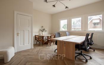 Bright furnished office space rental at Emmalaan 7-9, featuring natural light and a stylish meeting area. Ideal office to rent in Amsterdam Old South.