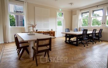 Bright, spacious office at Emmalaan 7-9 in Amsterdam Old South, featuring parquet flooring and modern furnishings. Ideal for rent office space with ample natural light and stylish seating.