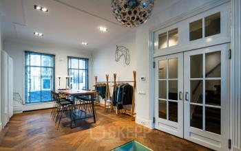 Bright office space to rent at PC Hooftstraat 150, Amsterdam Old South, featuring a stylish conference room with modern furniture and wooden flooring.