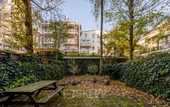Exterior view of a courtyard surrounded by greenery at PC Hooftstraat 150, ideal for rent office space in Amsterdam Old South.