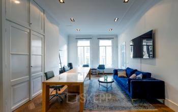 Furnished office space rental at PC Hooftstraat 150 in Amsterdam Old South with modern table, chairs, sofas, and large windows.