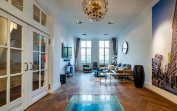 Spacious and stylish office space with modern furnishings at PC Hooftstraat 150, Amsterdam Old South, available for rent. Features a well-lit, open workspace with contemporary decor and large windows.