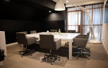 Modern conference room with a large table and six chairs at Olympisch Stadion 24-28 in Amsterdam Old South, ideal for office space rental.
