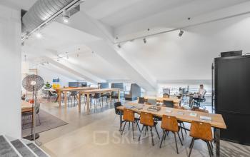 Bright office space at Olympisch Stadion 24-28, Amsterdam Old South, featuring modern workstations with people working. Ideal for office space rental.