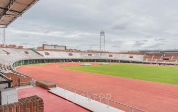 View of an Olympic stadium with a running track and seating areas, located in Amsterdam Old South.