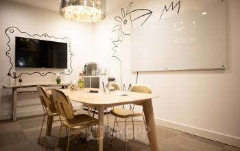 Modern office space with a large table, stylish chairs, TV, and a whiteboard at Olympisch Stadion 24-28, Amsterdam Old South, ideal for office space rental.