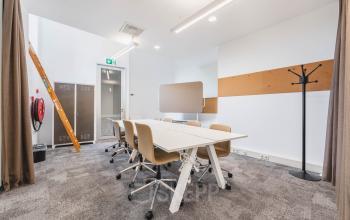 Furnished office space for rent at Olympisch Stadion 24-28, Amsterdam Old South, featuring a modern meeting area with conference table and chairs.