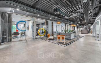 Stylish office space for rent at Olympisch Stadion 24-28, Amsterdam Old South, featuring modern furnishings, seating areas, and meeting rooms with colorful accents.