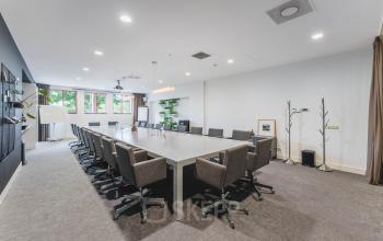 Spacious conference room with a long table and chairs in an office space available for rent at Olympisch Stadion 24-28, Amsterdam Old South.
