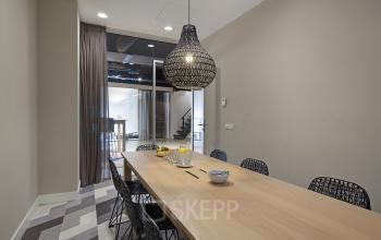 Interior conference room at Olympisch Stadion 24-28 in Amsterdam Old South with modern decor, large wooden table, and stylish lighting, available for office space rental.