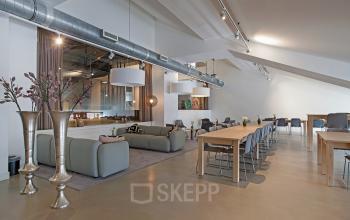 Modern office space rental at Olympisch Stadion 24-28, Amsterdam Old South, featuring an open floor plan with stylish furnishings and contemporary lighting.