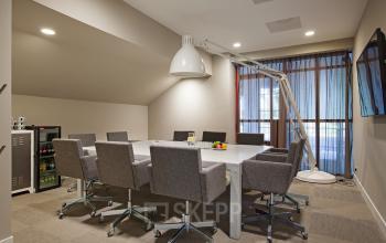 Modern conference room with a large table, grey chairs, and a minimalist design at Olympisch Stadion 24-28 in Amsterdam Old South, Amsterdam. Ideal for office space rental.