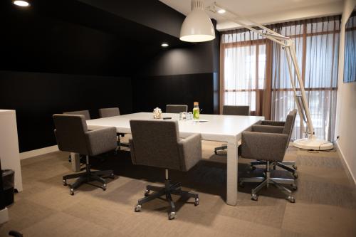 Modern conference room with a large table and six chairs at Olympisch Stadion 24-28 in Amsterdam Old South, ideal for office space rental.