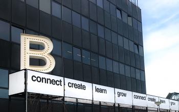 Modern façade of an office to rent at Johan Huizingalaan 761-763 a, Amsterdam Riekerpolder, with a sign encouraging growth and connection.