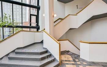 Modern staircase with golden handrails within an Amsterdam Sloterdijk office space rental at Kingsfordweg 151.