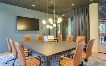 Modern conference room available for office space rental at Kingsfordweg 151, Amsterdam Sloterdijk, featuring a large table with plush chairs.