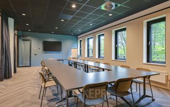 Modern conference room at Kingsfordweg 151 offering an office space rental in Amsterdam Sloterdijk, equipped with a large table, chairs, and presentation screen.