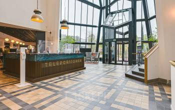 Modern office space rental at Kingsfordweg 151, Amsterdam Sloterdijk, featuring a stylish reception area with high ceilings and natural light.