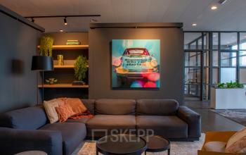 Furnished office space at Teleportboulevard 110 in Amsterdam Sloterdijk featuring a comfortable seating area, artwork, and ambient lighting, ideal for office space rental.