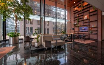 Modern office space for rent at Teleportboulevard 110, Amsterdam Sloterdijk, featuring a stylish furnished interior with seating areas and large windows.