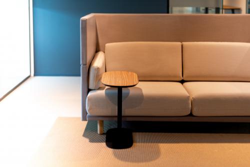 Modern lounge area at Kabelweg 37 in Amsterdam Sloterdijk, featuring a stylish sofa and a compact wooden table, ideal for office space rental.