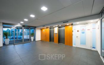 Spacious office entrance at Radarweg 501, Amsterdam Sloterdijk, featuring two elevators and large glass doors. Ideal for those seeking office space rental in a convenient location.