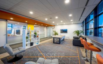 Bright, furnished office space rental at Radarweg 501, Amsterdam Sloterdijk, featuring a modern open floorplan with vibrant seating and plants. Ideal for businesses looking to rent office space with style.