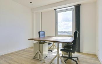 Bright office space with wooden floors, a modern desk, and ergonomic chairs, perfect for professionals seeking office space rental at Tijnmuiden 59, Amsterdam Sloterdijk.