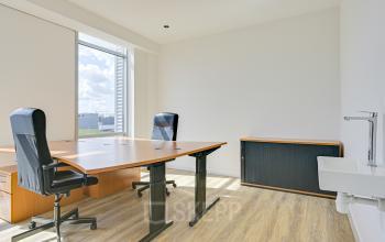 Bright office space with two large desks and office chairs at Tijnmuiden 59, Amsterdam Sloterdijk. Offers a clean, modern environment for office space rental with ample natural light.