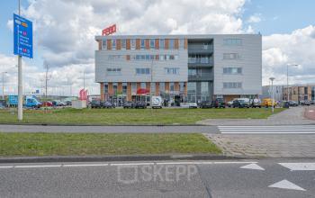 Exterior view of the office building at Tijnmuiden 59, Amsterdam Sloterdijk, showcasing a modern facade with ample parking space available for rent office space.