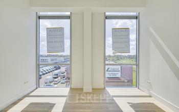 Bright, unfurnished office space at Tijnmuiden 59, Amsterdam Sloterdijk, featuring large windows with views of the business park. Ideal for office space rental.