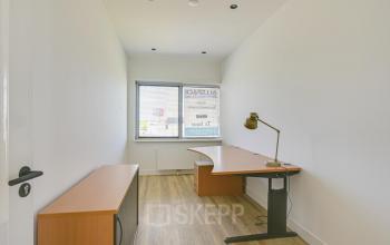 Simple office space located at Tijnmuiden 59 in Amsterdam Sloterdijk, featuring a wooden desk and a window with natural light. Perfect for those seeking efficient office space rental in a convenient location.