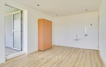 Unfurnished interior of Tijnmuiden 59, Amsterdam Sloterdijk, featuring a wooden floor and a built-in storage cabinet, ideal for office space rental.