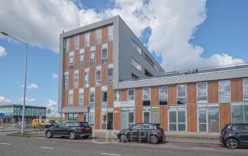 Exterior view of modern office building at Tijnmuiden 59, Amsterdam Sloterdijk, showing a sleek facade with large windows. Ideal for office space rental with convenient access and ample natural light.