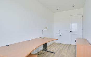 Simple office space with wooden desk and lamp at Tijnmuiden 59, Amsterdam Sloterdijk, ideal for office space rental.