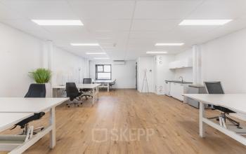 Modern office space at Arlandaweg 92, Amsterdam Sloterdijk, featuring wooden flooring, white walls, and a kitchenette, ideal for businesses seeking office space rental.