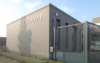 Exterior view of a modern office building at Elektronstraat 15, Amsterdam Sloterdijk, surrounded by a secure gate.