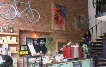 Cozy office space rental at Overtoom 141, Amsterdam West, with exposed brick walls and a café-style setting.