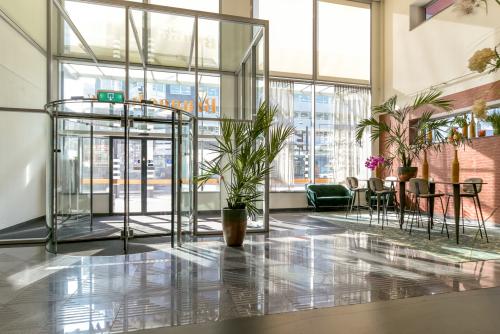 Bright, spacious office entrance at Bos en Lommerplein 280, Amsterdam West, featuring modern decor, seating area, and natural light – ideal for office space rental.