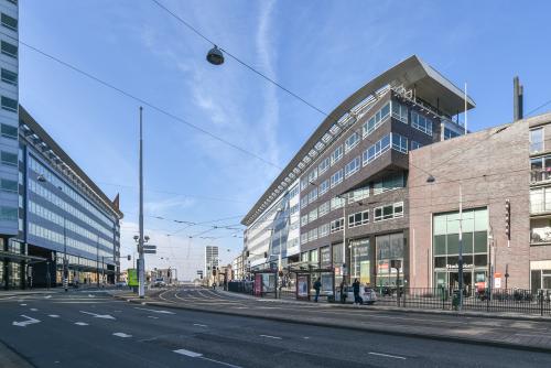 Exterior view of Bos en Lommerplein 280, Amsterdam West, showcasing modern office building architecture ideal for office space rental, with tram lines in the foreground leading to the bustling city center.