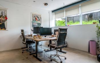 Cozy office space at Bos en Lommerplantsoen 1, Amsterdam West, featuring modern desks and chairs under ample natural light, ideal for office space rental.
