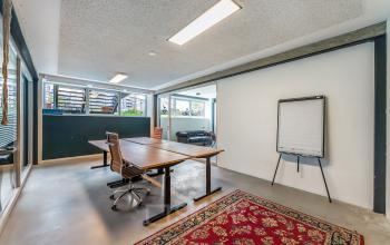 Spacious office to rent in Amsterdam West at Bos en Lommerplantsoen 1, featuring a large table with chairs and modern lighting, ideal for collaborative work. Perfect choice for office space rental.