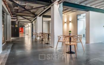 Bright office interior with modern furnishings and stylish seating areas, located at Bos en Lommerplantsoen 1, Amsterdam West, ideal for those looking to rent office space.
