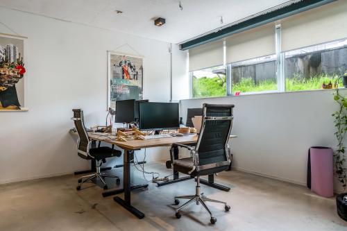 Cozy office space at Bos en Lommerplantsoen 1, Amsterdam West, featuring modern desks and chairs under ample natural light, ideal for office space rental.