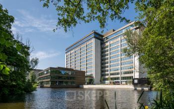Modern office building at Nachtwachtlaan 20, Amsterdam West, featuring large windows and surrounded by greenery, ideal for office space rental.